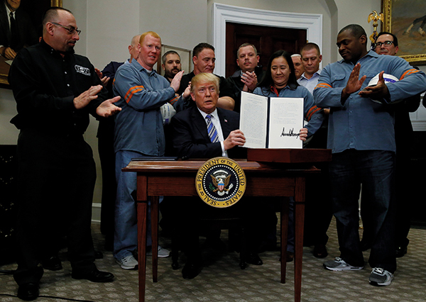 ⓒReuter 3월8일 백악관에서 철강 업계 노동자와 노조 인사들이 참석한 가운데 트럼프 미국 대통령이 외국산 철강·알루미늄에 대한 관세 부과 명령서를 들어 보이고 있다.