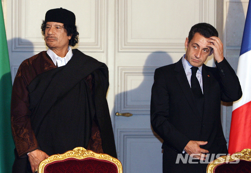 【파리 = AP/뉴시스】차미례 기자 = 2007년 12월 10일 프랑스를 국빈방문한 모아마르 가다피 리비아 당시 대통령과 사르코지가 엘리제궁에서 만나고 있다 (AP자료사진).  사르코지는 3월 20일 가다피로부터 거액 선거자금을 받은 혐의로 체포되어 낭테르 경찰서에서 조사를 받고 있다.