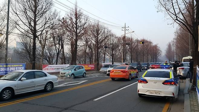 케이티연구개발센터 앞 도로 풍경. 케이티가 비표를 소지하지 않은 주주와 취재진들의 차를 막으면서 앞 길이 막혀 교통 체증을 빚고 있다. 경찰차까지 출동했다.