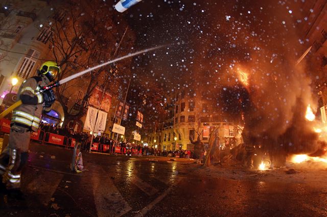 스페인 발렌시아에서 열린 라스 파야스 축제 마지막 날에 '파야'를 불태우는 행사가 진행되는 가운데 소방관이 불길을 잡고 있다. AP 연합뉴스