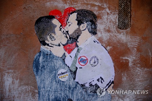 이탈리아 새 의회가 개원한 23일 로마 시내에 루이지 디 마이오(왼쪽) 오성운동 대표와 마테오 살비니 동맹 대표가 키스하는 벽화가 발견됐다.