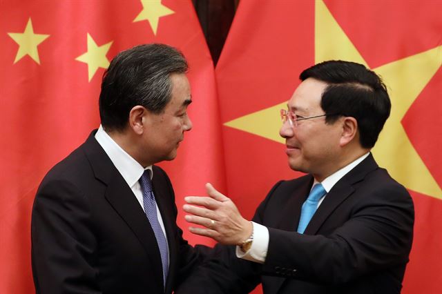베트남을 방문 중인 왕이(왼쪽) 중국 외교부장이 지난 1일 하노이에서 팜 빈 민 베트남 부총리겸 외무장관과 회동하고 있다. 이들은 양국 관계가 매우 긍정적인 방향으로 가고 있다고 밝혔지만, 베트남 일반인들의 생각은 많이 다르다. 하노이=EPA 연합뉴스