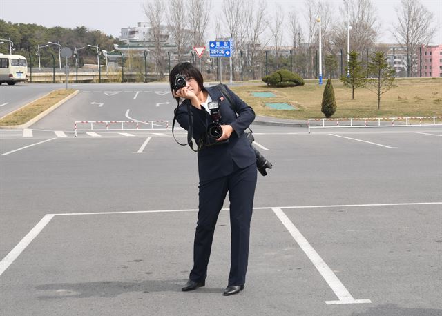 남측 기자단의 평양순안공항 도착 기념사진을 찍어주고 있는 북측 로금순 조선신보 기자.