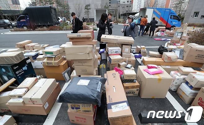 택배 전쟁이 벌어지고 있는 경기도 남양주 다산신도시의 한 아파트단지에서 입주민들이 주차장 바닥에 놓인 택배를 찾고 있다. 2018.4.10 © News1 이재명 기자
