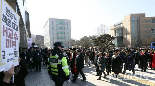 【서울=뉴시스】최진석 기자 = 2일 오전 서울 관악구 서울대학교에서 열린 '2018학년도 입학식'에서 H교수 사건 대응을 위한 학생모임 회원들이 입장하는 성낙인 서울대총장을 비롯한 교수들을 향해 H교수 파면 촉구 피켓을 들고 있다. 2018.03.02. myjs@newsis.com