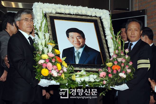 노무현 대통령이 서거한 날 밤, 문재인 변호사(왼쪽)가 노대통령의 영정사진을 경남 김해 봉하마을 회관앞에 차려진 빈소로 옮기고 있다. 2009.5.23 / 서성일 기자