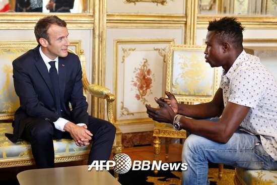 에마뉘엘 마크롱 프랑스 대통령과 아이를 구한 '스파이더맨' 마무두 가사마가 28일(현지시간) 엘리제궁에서 대화를 나누고 있다.  /AFPBBNews=뉴스1