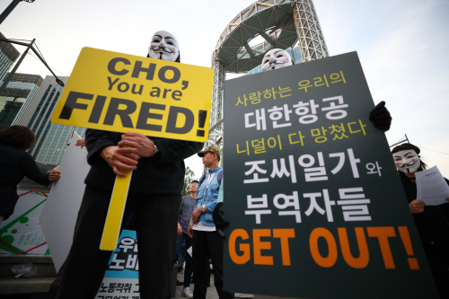 25일 오후 서울 종로구 보신각 앞에서 열린 한진그룹 조양호 일가 및 경영진 퇴진 촉구 4차 집회에 참가한 대한항공 직원이 피켓을 들고 있다.