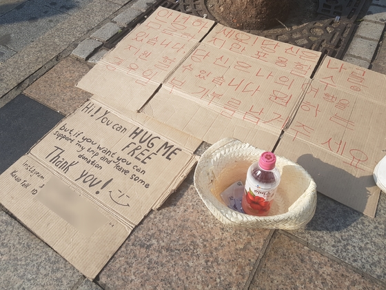 홍대입구에서 프리허그를 하는 베그패커들이 기부를 요청하는 문구. 김지아 기자