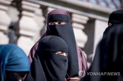31일(현지시간) 코펜하겐에서 열린 덴마크 의회에서 니캅을 착용한 여성들이 빠져나가고 있다. [EPA=연합뉴스]
