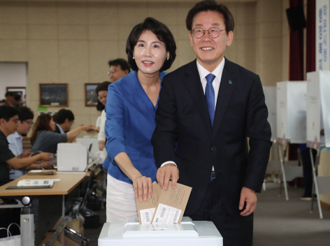 (사진=연합뉴스) 이 후보와 김씨가 6·13 전국지방선거 사전투표를 하는 모습