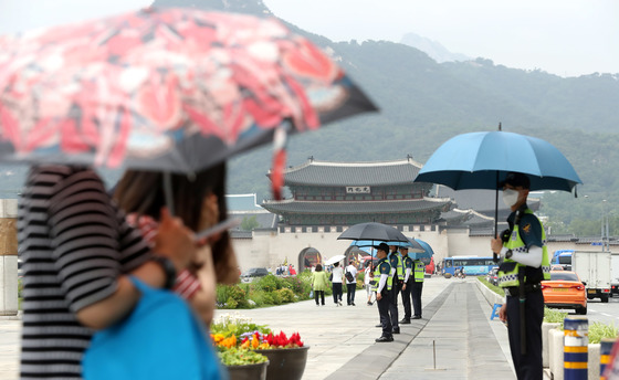 오존과 자외선 농도가 전국적으로 나쁨 수준을 보인 지난 8일 오후 서울 종로구 광화문 광장에서 경찰들이 햇볕을 피하기 위해 우산을 쓰고 있다. [뉴시스]