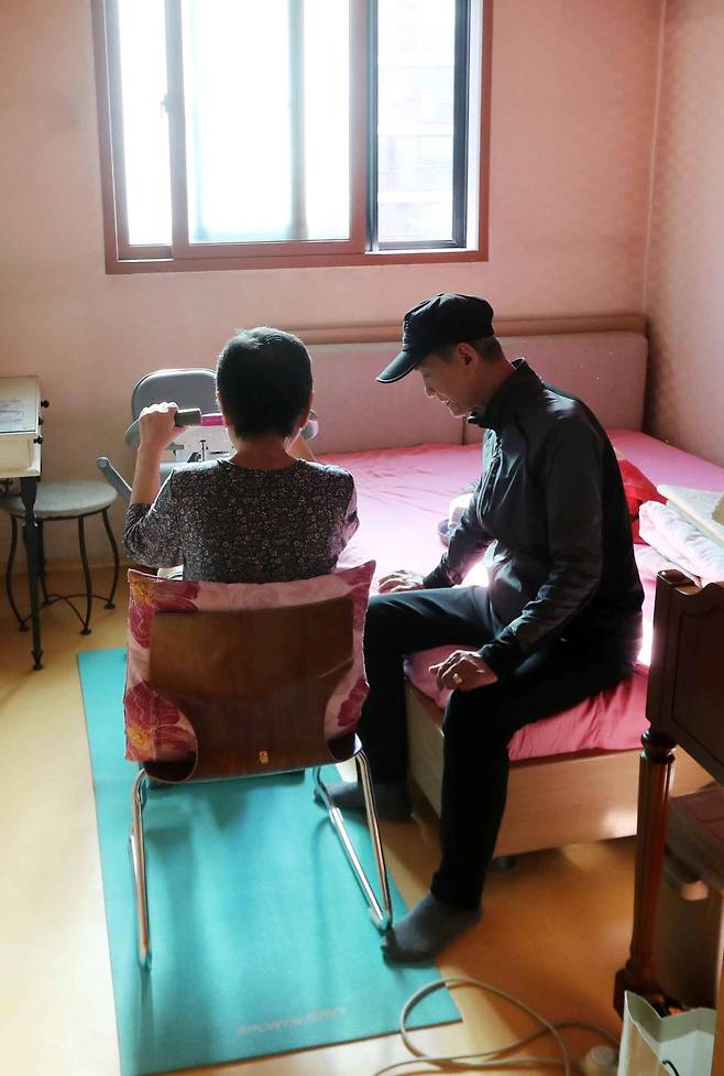 김영각(71)씨가 담관암·뇌졸중을 앓는 부인(70)이 집 안에서 재활 운동을 하는 걸 돕고 있다. [김상선 기자]