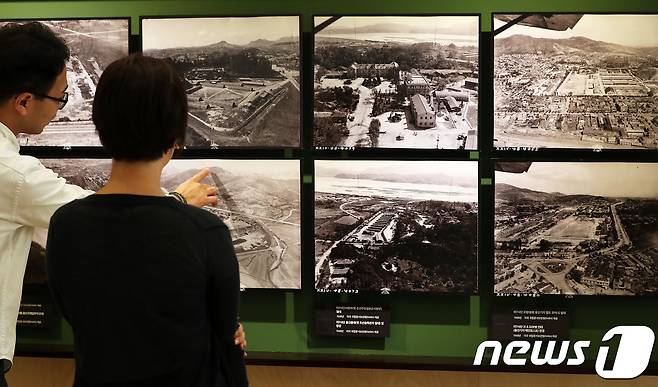 지난해 8월 서울 종로구 서울역사박물관 로비 전시실에서 열린 '용산, 금단의 땅을 전하다'전에서 관람객들이 최초 공개되는 1948년 당시 용산미군기지를 담은 항공사진을 살펴보고 있다. © News1 오대일 기자