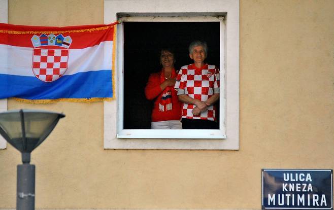 보스니아의 크로아티아계 주민들이 창가에 크로아티아 국기를 걸어놓고 승리를 축하하고 있다.[AFP=연합뉴스]