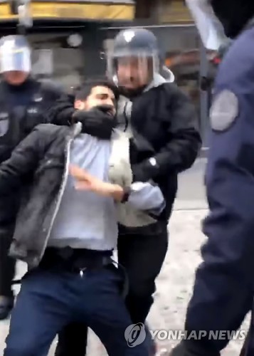 지난 5월 1일 파리 시내 노동절 집회에서 경찰용 헬멧을 쓰고 시위대로 보이는 시민을 제압하는 알렉상드르 베날라  [AFP/ Taha Bouhafs 제공=연합뉴스]