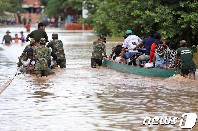 캄보디아 군인들이 스퉁트렝주 북부의 이재민들을 나무 배에 실어 나르고 있다. © AFP=뉴스1