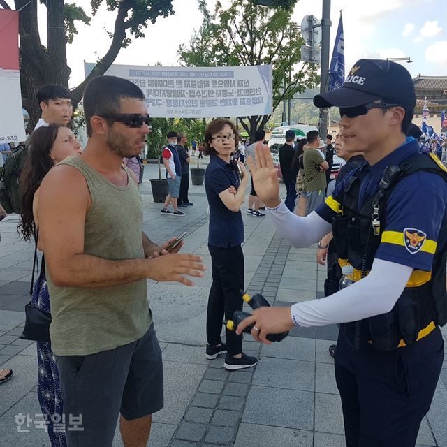 4일 오후 서울 종로구 광화문광장 인근에서 여성단체 집회를 촬영하던 남성이 경찰에 의해 제지되고 있다. 김형준 기자