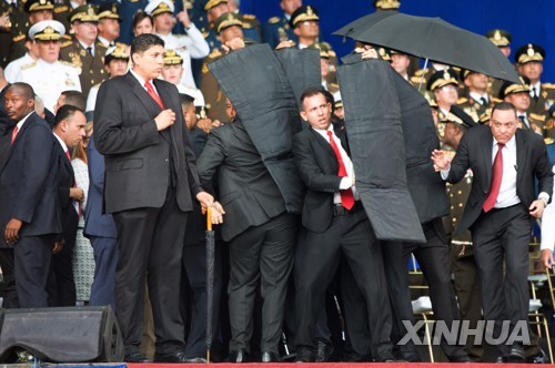 4일(현지시간) 마두로 베네수엘라 대통령의 연설 도중 인근 상공에서 폭발물이 터지자 경호원들이 방탄 장비로 마두로 대통령을 둘러싸고 있다.[신화=연합뉴스]