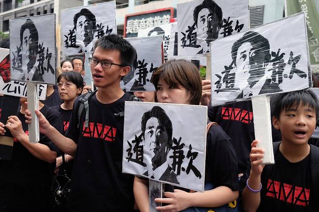 △대만 시민단체들이 타이페이 주대만일본대사관 앞에서 아베신조 일본 총리의 얼굴이 그려진 팻말을 들고 위안부 문제에 대한 일본 정부의 사죄를 요구하고 있다.[사진=AFP제공]