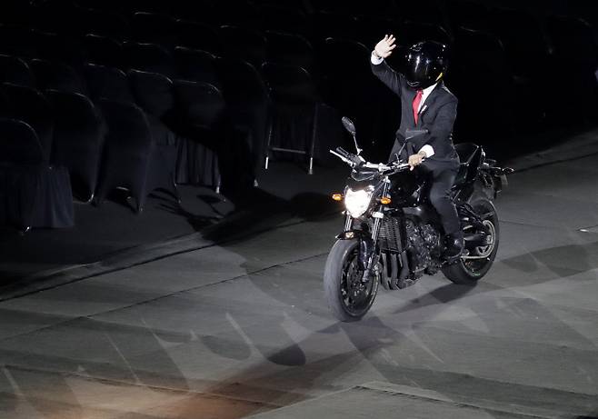 인도네시아 조코 위도도 대통령이 아시안게임 개막식 때 오토바이를 타고 나타나 팬들의 환호에 손을 흔들어 답하고 있다. | AP연합뉴스