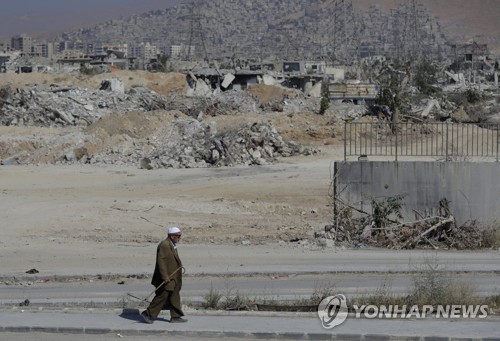 폐허가 된 마을을 거니는 시리아 노인 [AP=연합뉴스 자료사진]