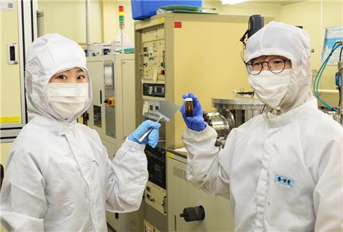 ETRI 홍성훈 박사(오른쪽)와 김수정 박사과정생이 실험에 사용한 기판과 용액(잉크)을 들어보이고 있다. [ETRI 제공=연합뉴스]