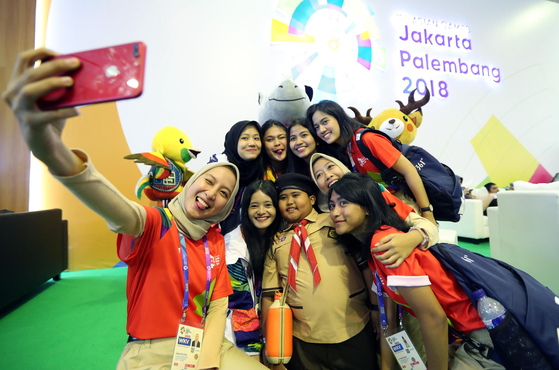 2018 자카르타-팔렘방 아시안게임 자원봉사자들이 2일 인도네시아 자카르타 컨벤션센터에 마련된 메인 프레스센터에서 한 어린이와 기념촬영을 하고 있다. 자카르타=김성룡 기자