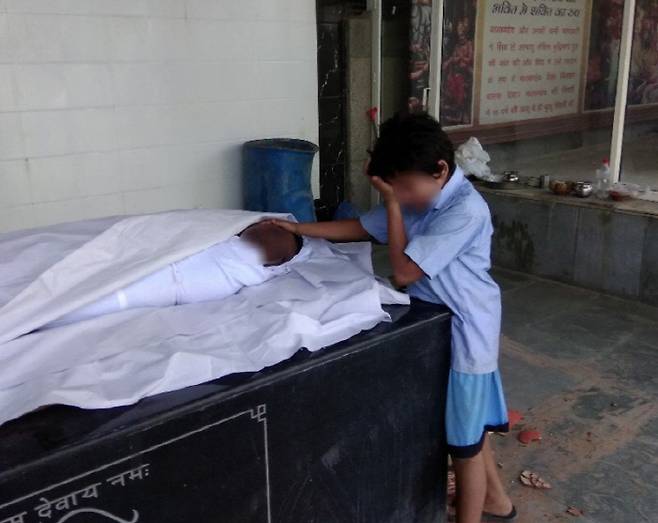 하수구 노동자 아닐의 시신 곁에서 울고 있는 아들. 쉬브 서니 기자 트위터 갈무리