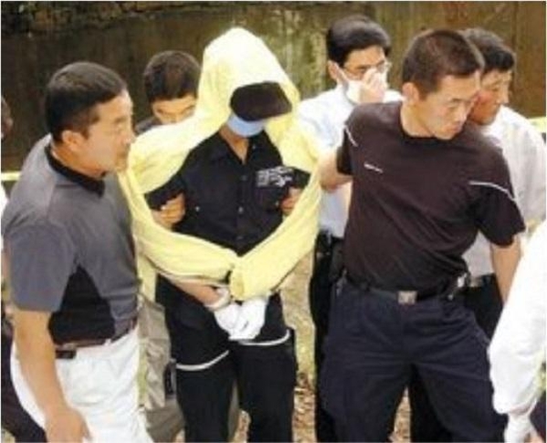 연쇄살인범 유영철이 지난 2004년 7월 18일 시체를 묻은 서울 봉원사 인근 안산 계곡에서 현장 검증을 하고 있다./공동취재단