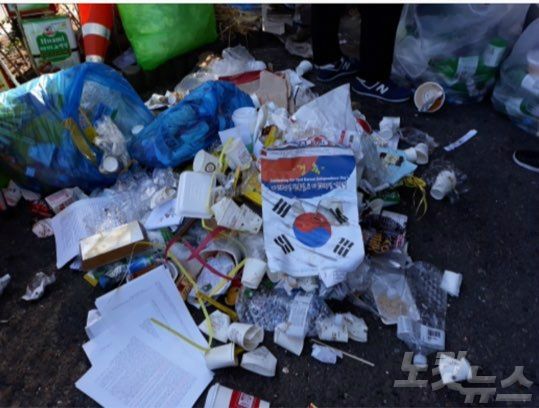 지난 20일 보수단체의 태극기집회 이후 서울역 광장에 버려진 쓰레기들. 태극기, A4용지를 비롯해 종이컵, 도시락 용기 등이 널려있다. (사진=독자 제공)