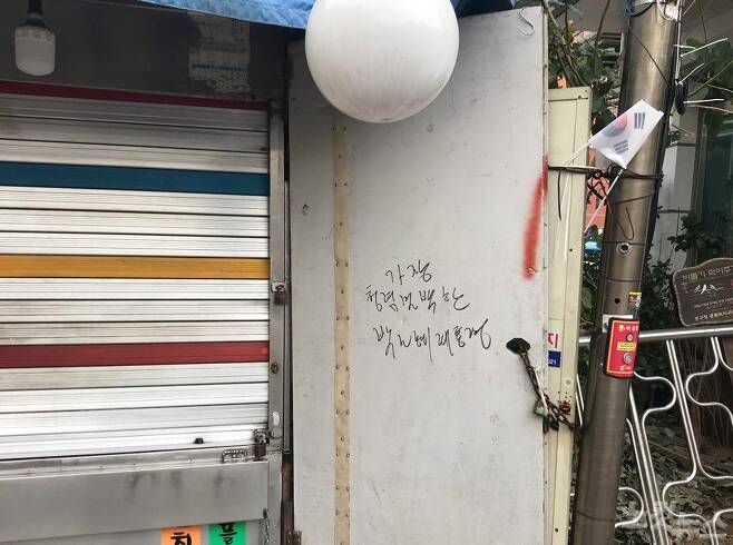 서울역 광장의 한 노상점포에 박근혜 전 대통령의 결백을 주장하는 낙서와 함께 태극기가 꽂혀 있다.