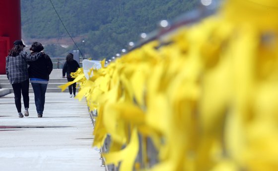 2014년 4월 전남 진도 팽목항에서 세월호 실종자 가족이 무사귀환을 바라는 노란 손수건들을 보며 걷고 있다. [중앙포토]