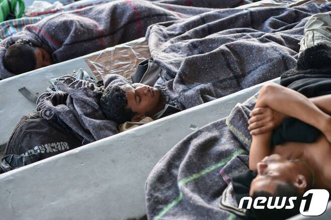 미국 남부 국경을 향해 북상하고 있는 중미 출신 이민자들이 5일(현지시간) 멕시코 수도 멕시코시티 소재 헤수스 마르티네스 스타디움에 설치된 임시수용시설에서 휴식을 하고 있다. © AFP=뉴스1