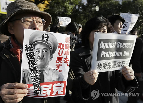 지난 2012년 일본 도쿄에서 열린 집회에서 아베 신조(安倍晋三) 일본 총리를 나치 독재자 히틀러로 묘사한 종이를 들고 있다. [EPA=연합뉴스 자료사진]