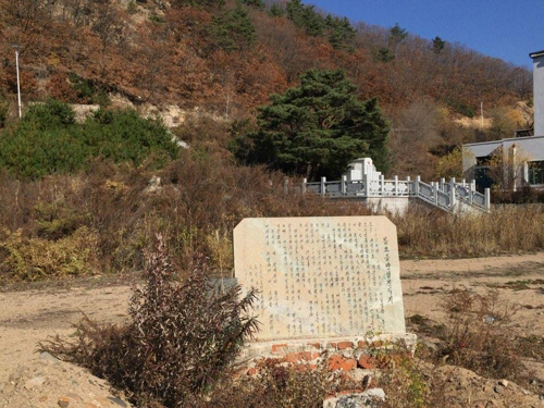 투먼의 봉오저수지 입구 부근에 방치된 옛 봉오동 전적비 뒤로 중국 당국이 새로 세운 전적비가 보인다.