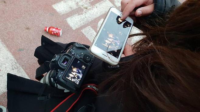 7일 오전 한 아이돌 팬이 자신이 찍은 케이비에스 ‘뮤직뱅크’ 출근길 사진을 살펴보고 있다.