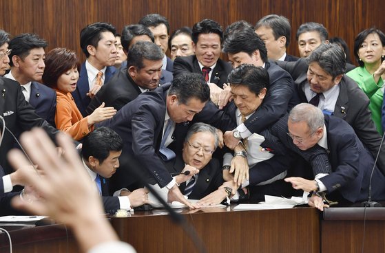 지난 8일 참의원 법무위원회에서 '출입국관리법' 개정안에 반대하는 야당의원들이 요코하마 신이치 법무위원장의 마이크를 뺏으며 의사진행을 방해하고 있다. 야당의 격한 반대에도 불구하고 과반수를 차지하는 여권의 압도적인 찬성으로 법안은 통과됐다.[AP=연합뉴스]