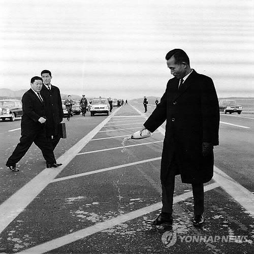 1968년 12월 21일 경인고속도로 개통식에 참석한 박정희 대통령이 노면에 샴페인을 뿌리며 기뻐하고 있다. [국가기록원 제공]
