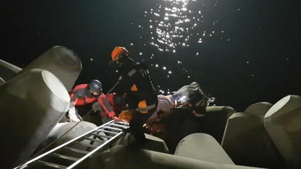 지난 16일 오후 10시쯤 부산 해운대구 마린시티 인근에서 5m 깊이의 방파제에 빠진 30대 여성을 소방대원들이 구조하고 있다. /부산 해운대소방서 제공