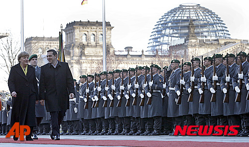 【베를린=AP/뉴시스】독일을 방문한 알렉시스 치프라스 그리스 총리(오른쪽)가 23일 베를린의 라이히스 타크 앞에서 앙겔라 메르켈 독일 총리와 함께 독일 군 의장대를 사열하고 있다. 2015.3.24