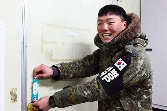 28사단 돌풍연대 DMZ GP 생활관에 ‘전우애를 당기세요’를 붙이는 정우준 병장.