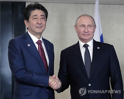 작년 11월 아베 신조 일본 총리(왼쪽)와 블라디미르 푸틴 러시아 대통령이 싱가포르에서 만나 악수를 나누는 모습 [EPA=연합뉴스 자료사진]