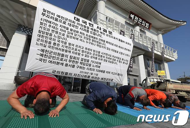 예천군의원 전원사퇴추진위원회와 예천군 주민들이 11일 오전 경북 예천군의회 앞에서 해외연수 도중 ‘가이드 폭행'으로 물의를 일으킨 박종철 의원을 비롯해 군의원을 잘못 선출한 책임에 대해 대국민 사과문 발표와 함께 108배를 올리고 있다. 2019.1.11/뉴스1 © News1 공정식 기자