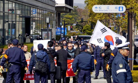 지난 2013년 시마네현이 주최한 다케시마의 날 행사가 열린 현민회관 밖에서 독도수호전국연대 등 한국 시민단체 회원들이 일본 경찰에 둘러싸인 채 태극기를 들고 항의시위를 벌이고 있다 [중앙포토].