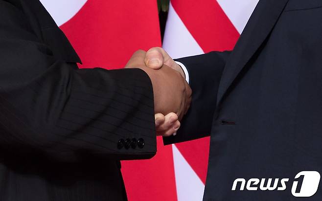 작년 6월12일 싱가포르에서 열린 첫 북미정상회담 당시 김정은 북한 국무위원장(왼쪽)과 도널드 트럼프 미국 대통령이 악수하는 모습. © AFP=뉴스1