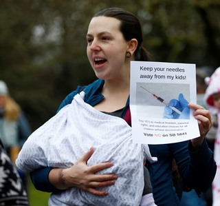 2월20일 미국 워싱턴에서 백신 접종 의무화에 반대하는 엄마들이 아이를 안고 행진하고 있다. REUTERS