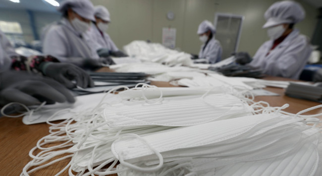 재난 수준의 미세먼지가 연일 계속되는 6일 경남 양산시 원동면에 있는 마스크 제조업체 주식회사 엠씨에서 직원이 분주히 제품을 만들고 있다. [연합]