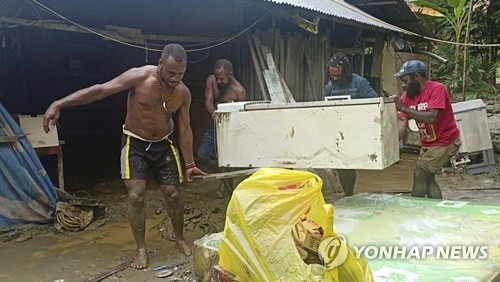 2019년 3월 18일 인도네시아 파푸아 주 자야푸라 군 센타니 지역에서 주민들이 홍수 피해를 입은 집에서 가재를 꺼내고 있다. [AP=연합뉴스]