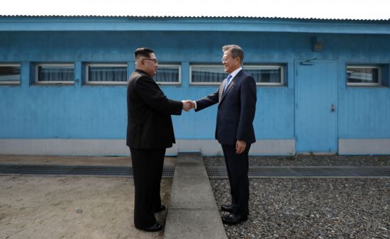 문재인 대통령과 북한 김정은 국무위원장이 4월 27일 판문점에서 군사분계선을 사이에 두고 악수하는 모습.